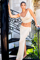 Woman in a white gold outfit standing on a staircase with a blurred background